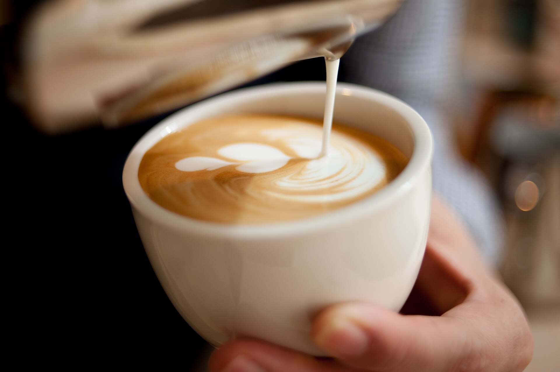 Un latte avec un dessin de mousse en forme de feuille
